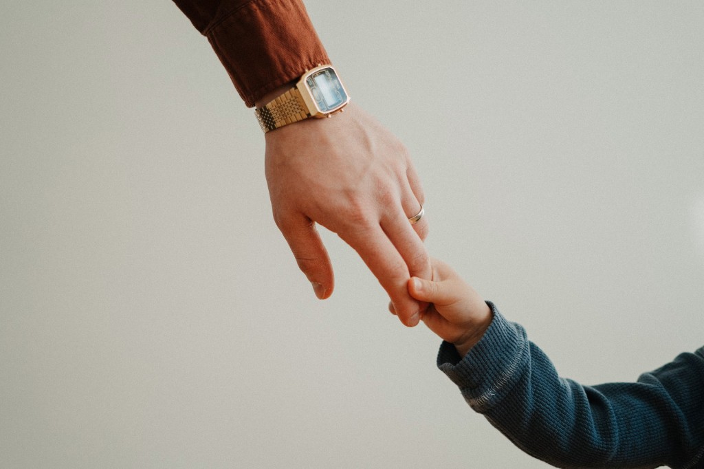 Parent gently holding a child's hand — compassionate fertility care at Shashwat IVF